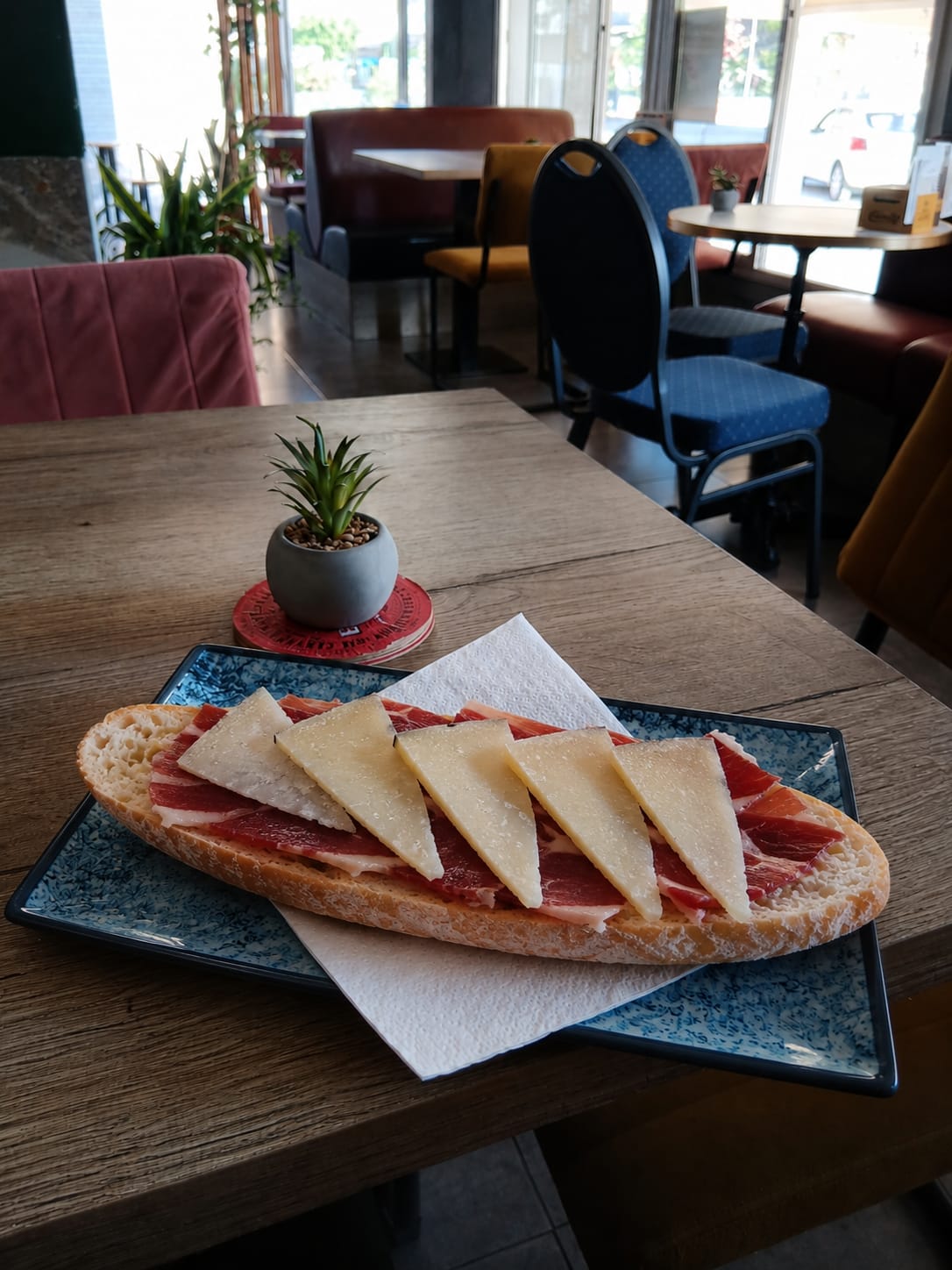 Tostada de jamón con queso en plato azul